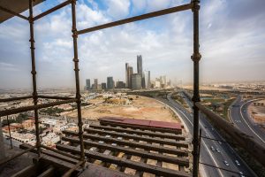 The King Abdullah financial district sits on the horizon seen from a skyscraper under construction in Riyadh, Saudi Arabia, on Sunday, Jan. 10, 2016. Saudi Arabian stocks led Gulf Arab markets lower after oil extended its slump from the lowest close since 2004. Photographer: Waseem Obaidi/Bloomberg